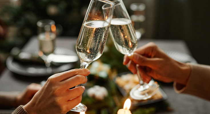 Two glasses of champagne being touched together for a new year's toast