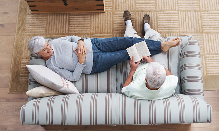 Man reading to woman as she lays down smiling at him