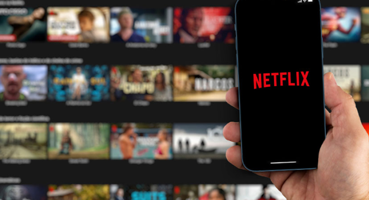 Netflix startup screen in background with phone displaying "Netflix" in foreground