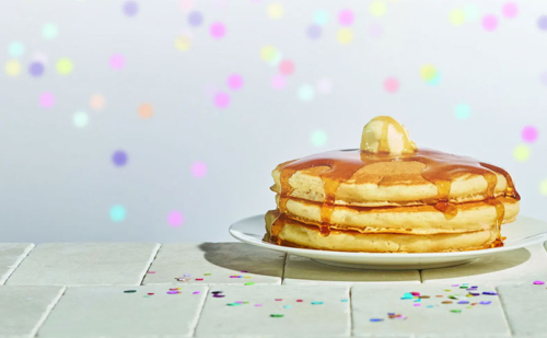 Image of short stack of pancakes from IHOP on a background with confetti