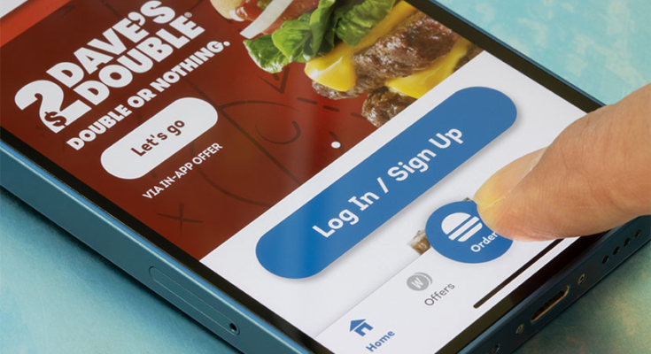 Picture of a smartphone with Wendy's app displayed and a finger pushing "order"