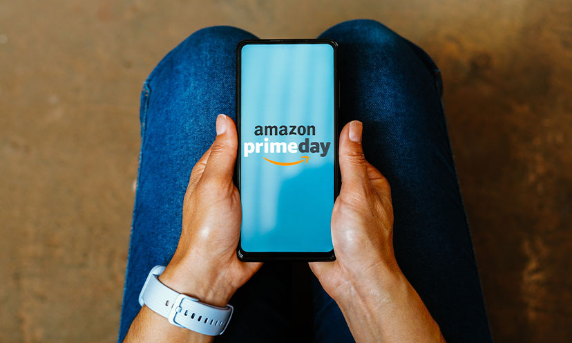 Hands holding a phone with "amazon prime day" on the screen