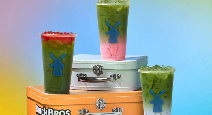 Matcha drinks in branded Dutch Bros cups on top of metal lunchboxes
