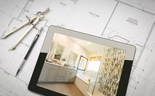 Picture of a tablet with an image of a bathroom on the screen sitting on top of architectural drawing plans