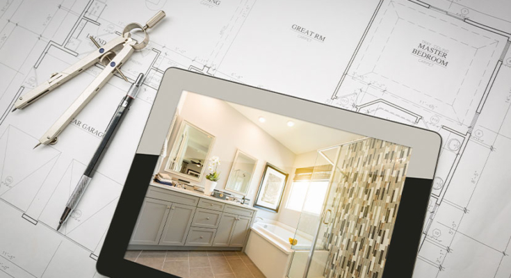 Picture of a tablet with an image of a bathroom on the screen sitting on top of architectural drawing plans