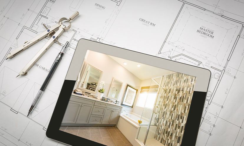 Picture of a tablet with an image of a bathroom on the screen sitting on top of architectural drawing plans