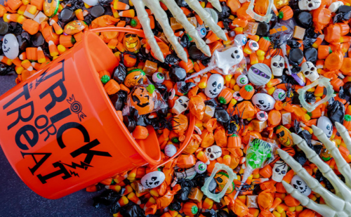Halloween candy spilling from a trick or treat bucket
